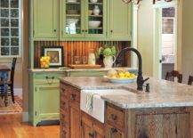 distressed wood kitchen island with green cabinets