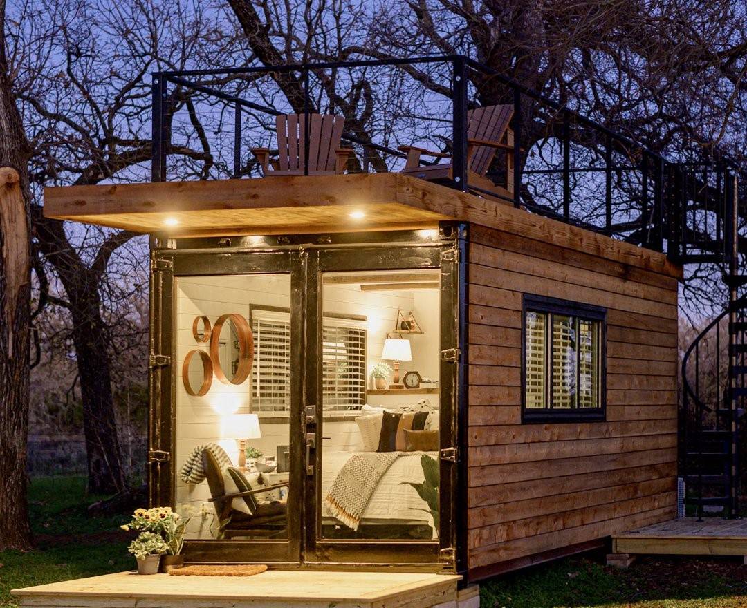 container home at night with bed and chair lit up