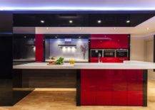 modern kitchen with low lighting and bright red cabinets