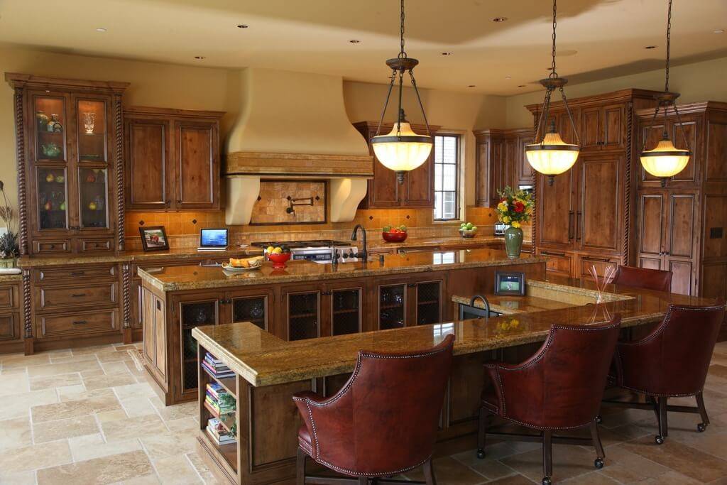 dark wood panelled kitchen with luxurious arm chairs at island