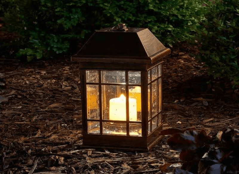 black rod iron lit lantern on ground