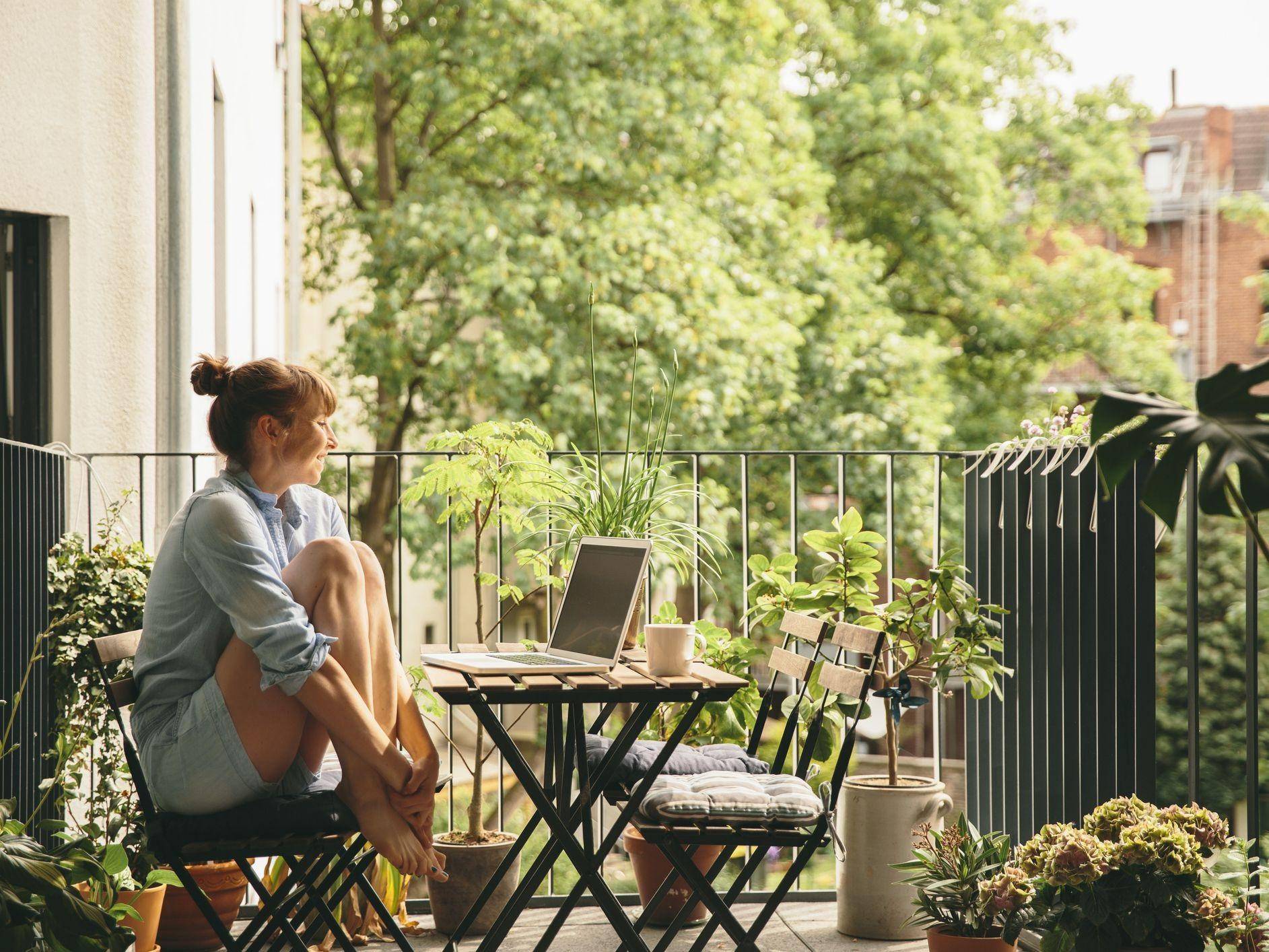 woman seated at patio table on balcony