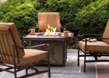lit firepit with beige chairs surrounding on patio
