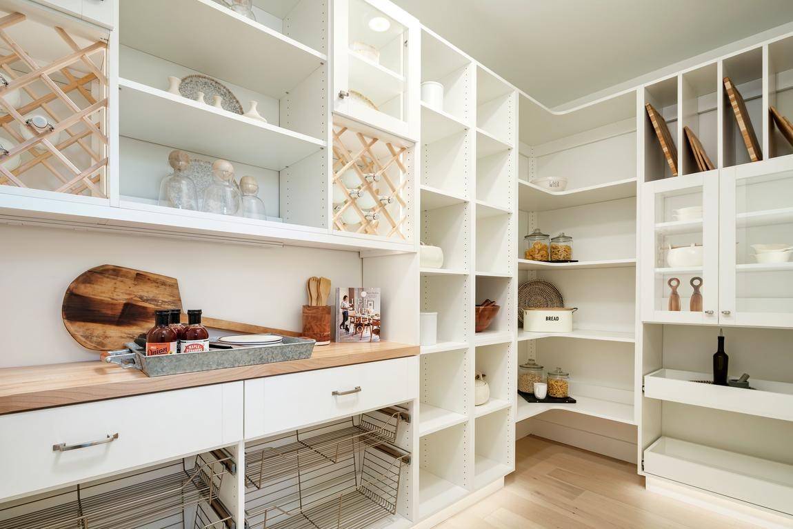 well organized walk-in pantry with different sizes of shelves