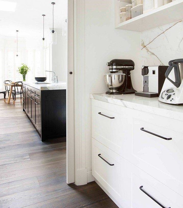 black cake mixer on a white countertop in open pantry