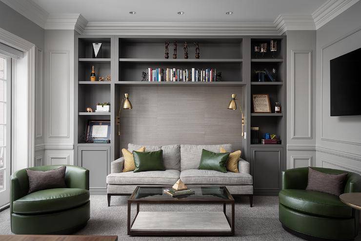 dark gray living room with green leather accent chairs pillows shelf