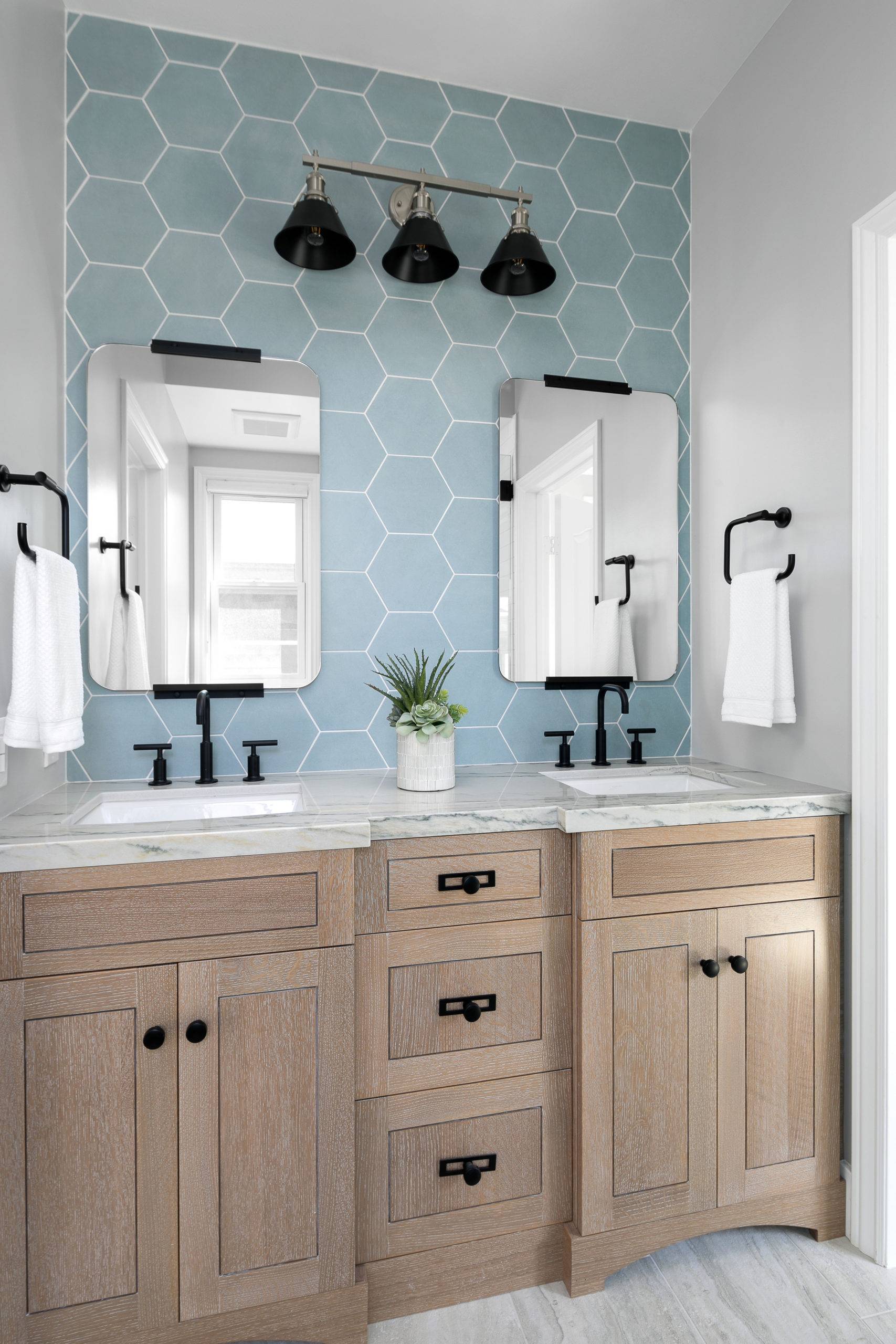 Gorgeous hexagonal tiled blue backsplash for the small beach style bathroom