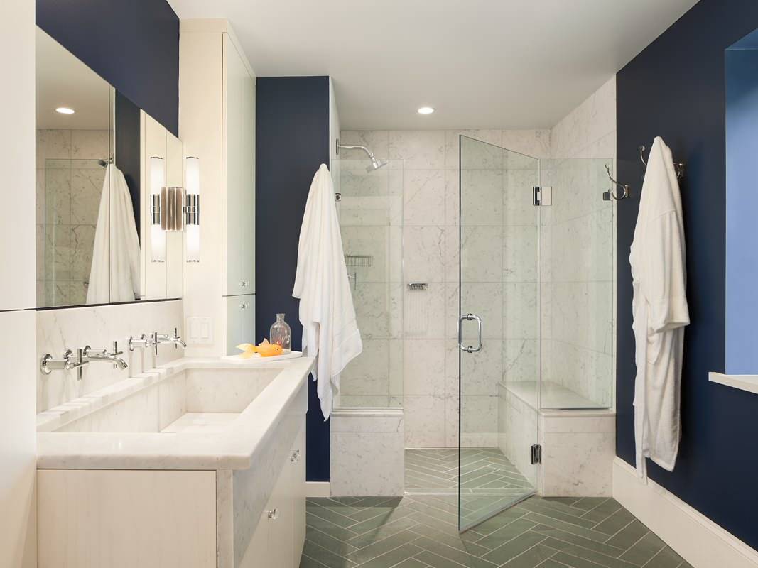 Gray bathroom floor tile in herringbone layout add pattern and color to the stylish small bathroom