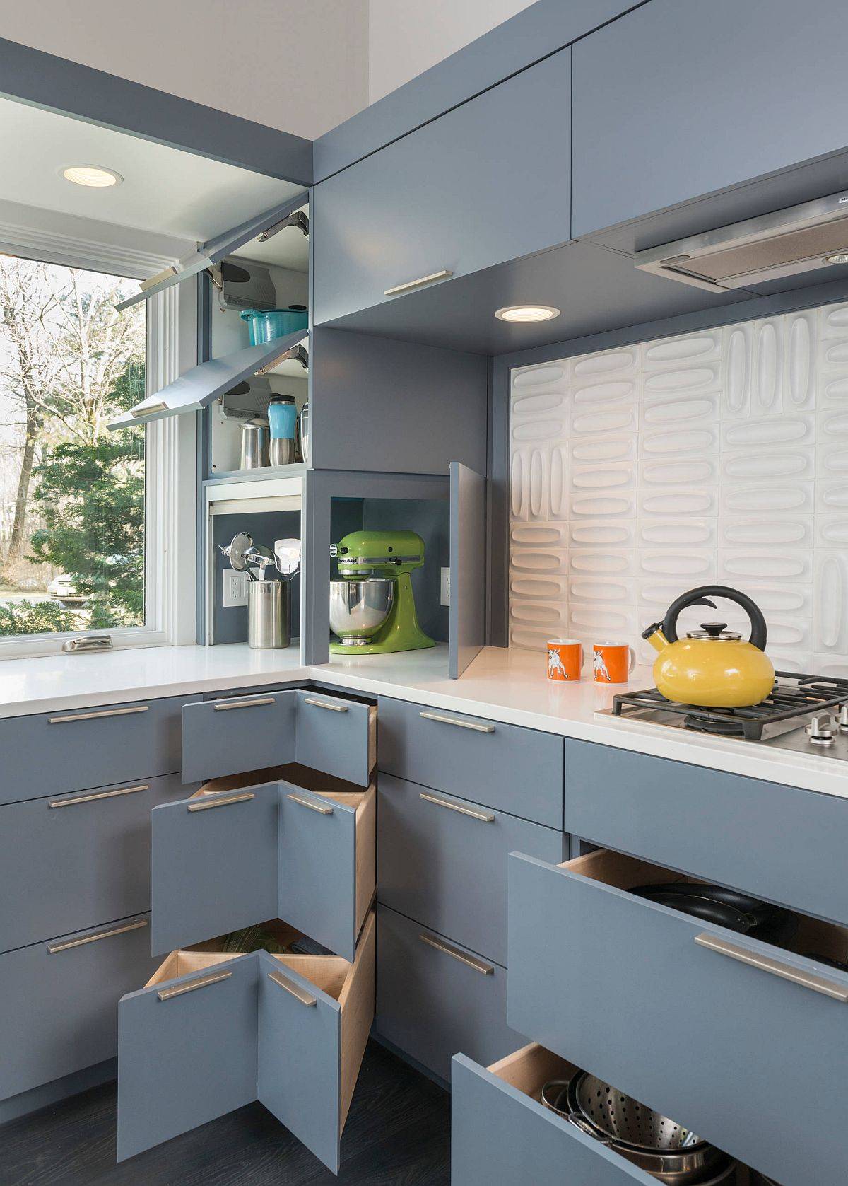 Gray corner cabinets and custom units offer a variety of delightful storage options in this kitchen