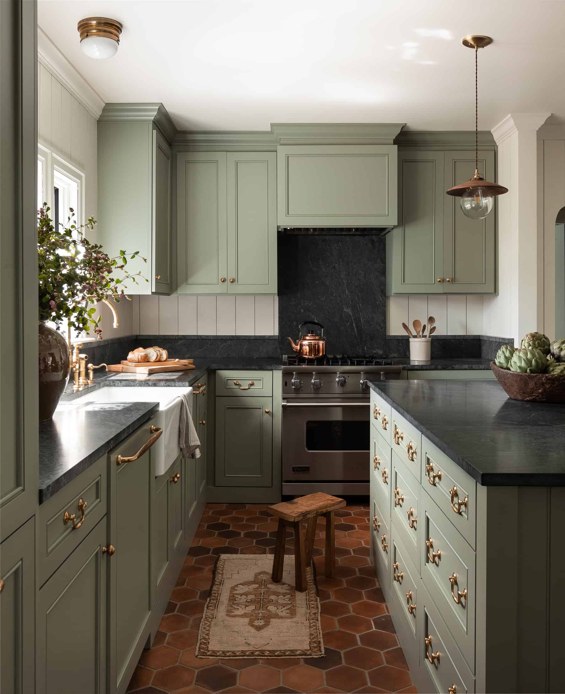 green kitchen cupboards with black onyx countertops