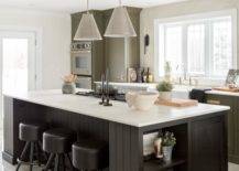 green kitchen cupboards with black island hanging pendants