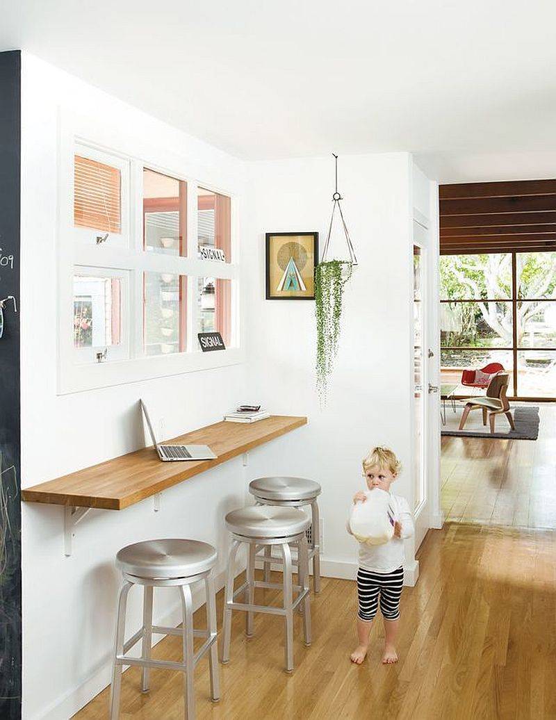 Slim wooden breakfast bar in the kitchen corner can also be used as a fabulous workstation