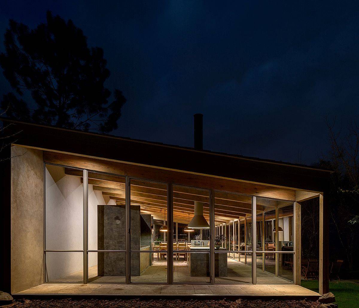 Sloped ceiling of the home is even more prominent after sunset thanks to warm lighting