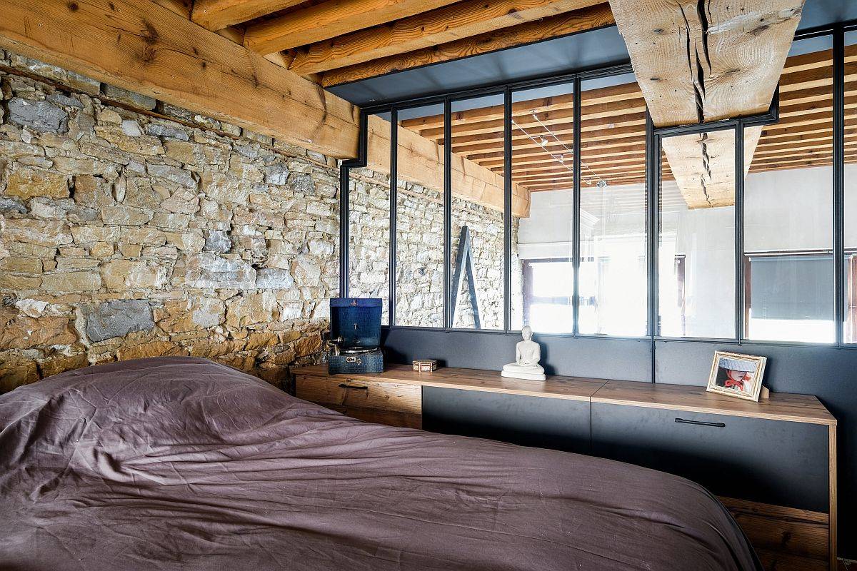 Stunning bachelor bedroom breaks away from the clutche sof gray with exposed stone and wood