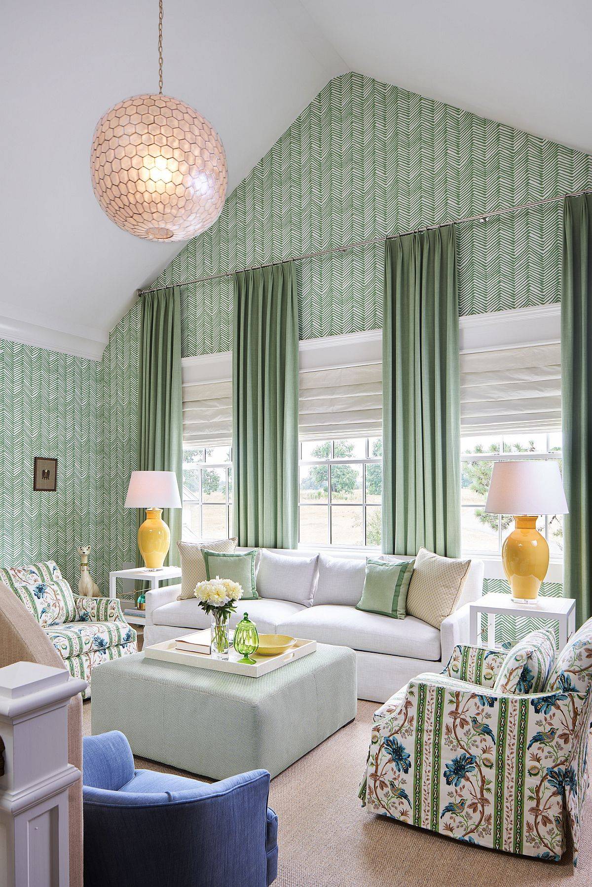 green wallpaper vaulted ceiling living room with large org hanging pendant white coach floral pattern club chairs ottoman curtains