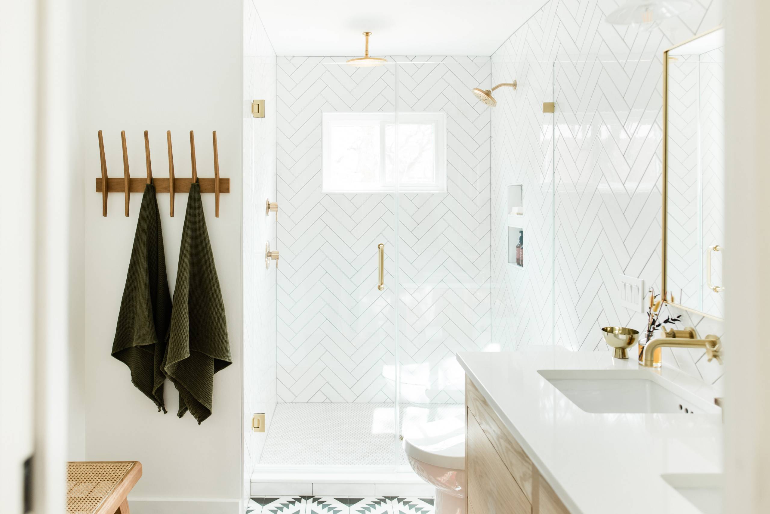 White, brass and wood bathroom with herringbone-pattterned shower area that makes a difference