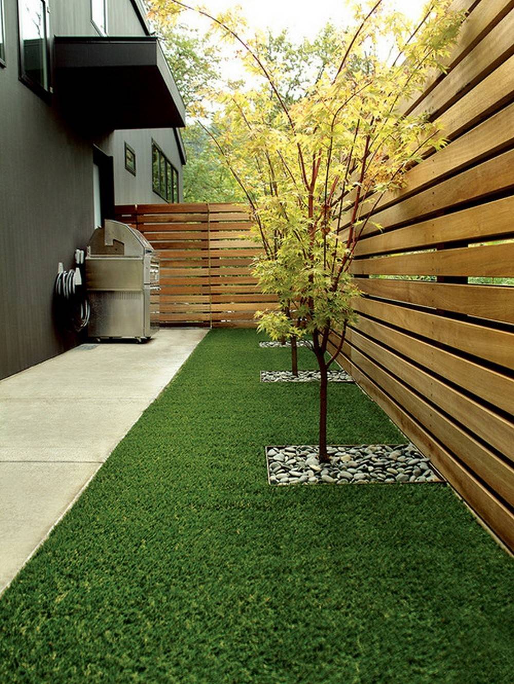 backyard pallet fence surrounding faux grass and barbecue 