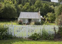 white picket fence in front of cottage