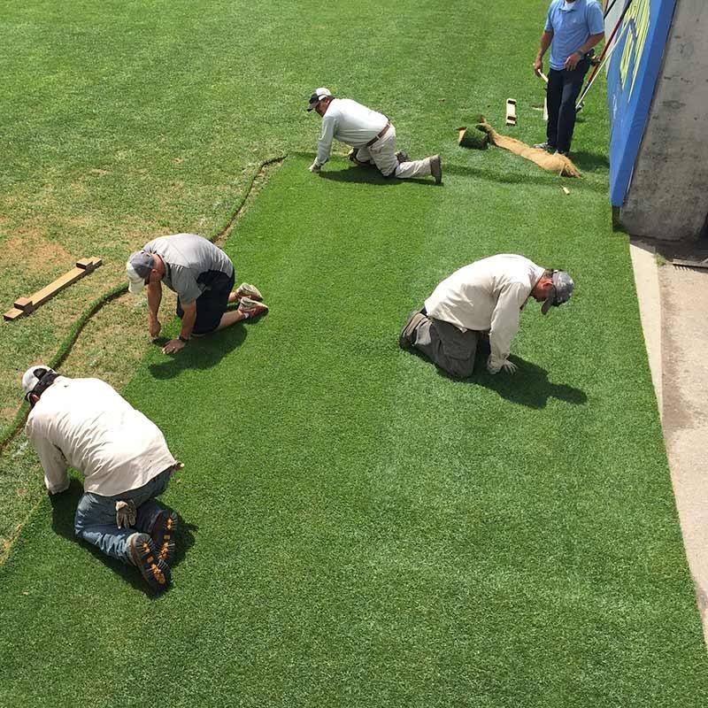 men laying down sod