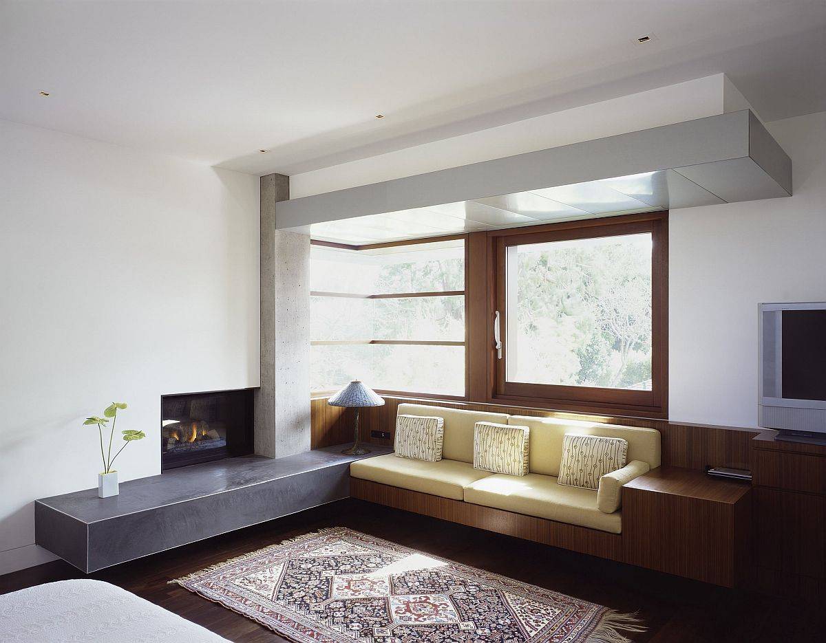 Beautiful wooden built-in bench next to the fireplace in wood feels minimal and modern