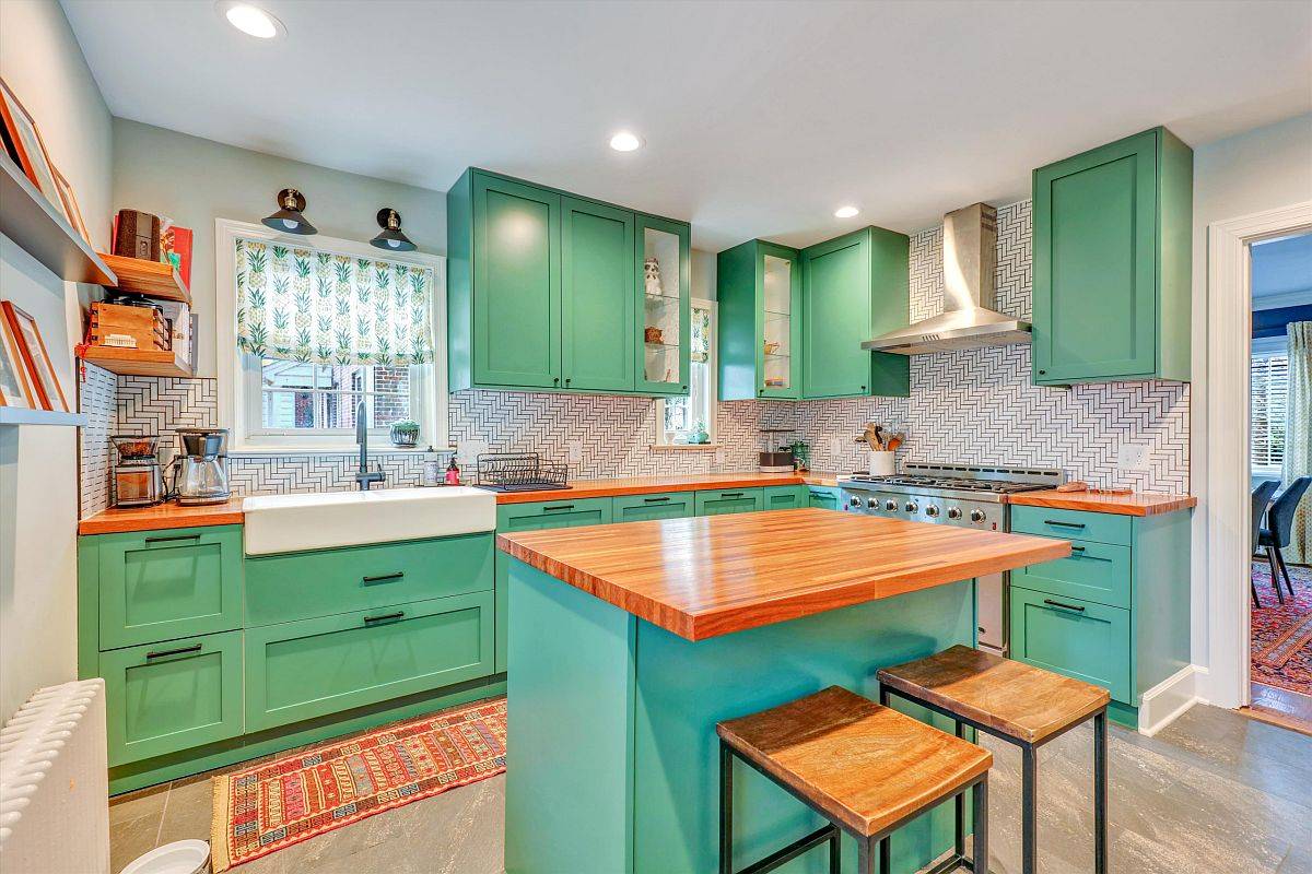 Bright and beautiful modern kitchen is draped in a lovely shade of sea green along with blue for the island