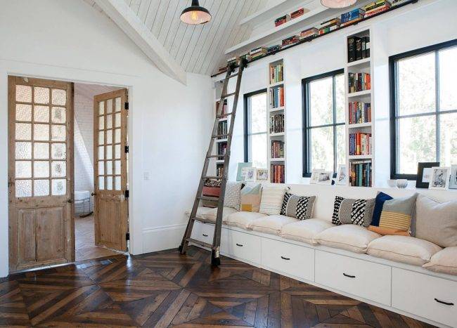 Large-built-in-bench-in-white-with-ample-drawer-space-and-bookshelves-all-around-is-a-great-addition-to-the-family-room-48877-217x155