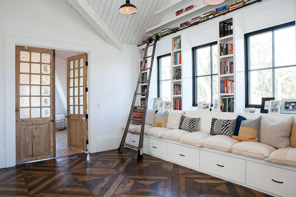 Large built-in bench in white with ample drawer space and bookshelves all around is a great addition to the family room