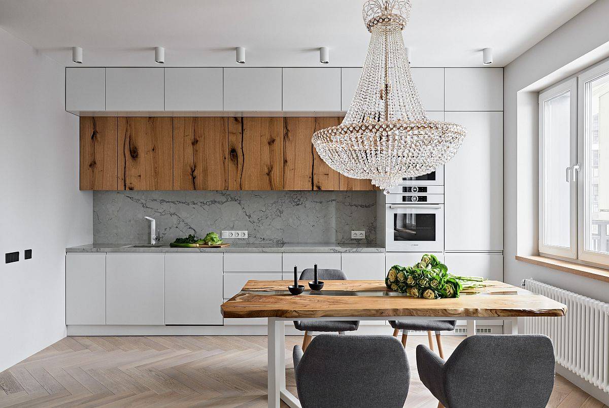 Live-edge table and woodsy cabinets add a cozy appeal to the white kitchen