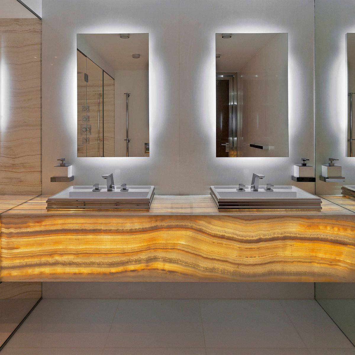 Luxurious bathroom with back-lit onyx countertops and mirrors