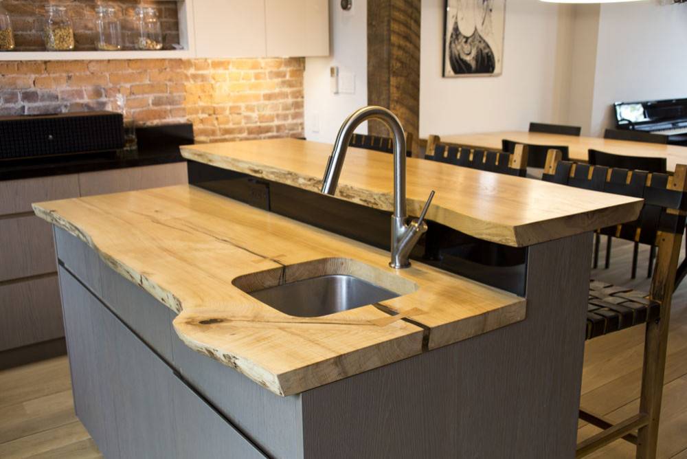 Multi-level kitchen island with counters in live-edge wood that makes ample difference