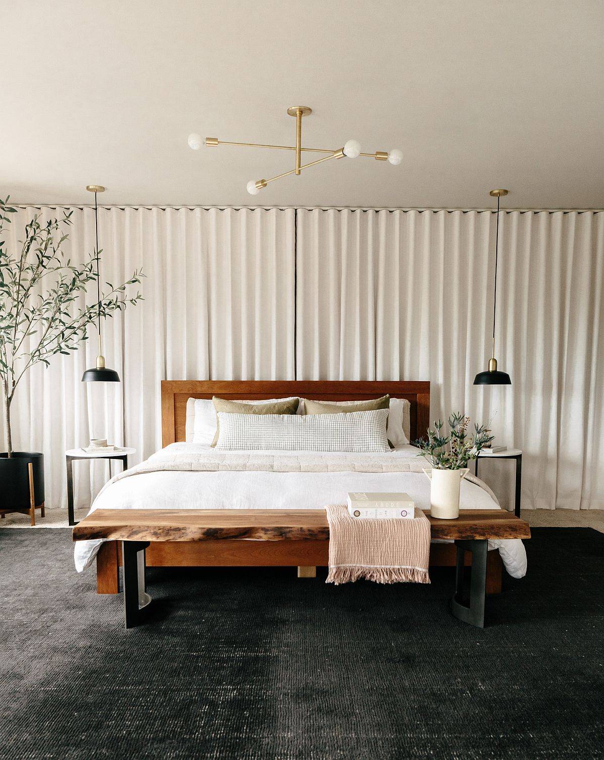 Naturel edge table at the foot of the bed, warm textures and lovely, simple backdrop create a cozy bedroom