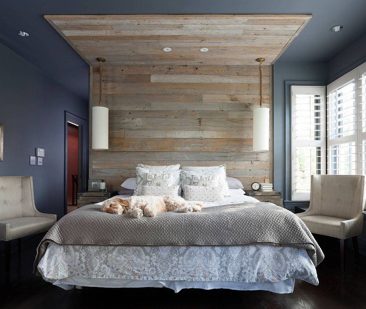 Reclaimed wooden panels create a headboard that goes all the way up to the ceiling