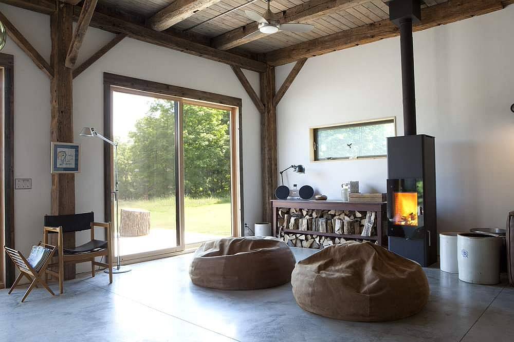 Stacked firewood and modren fireplace bring warmth to this living room