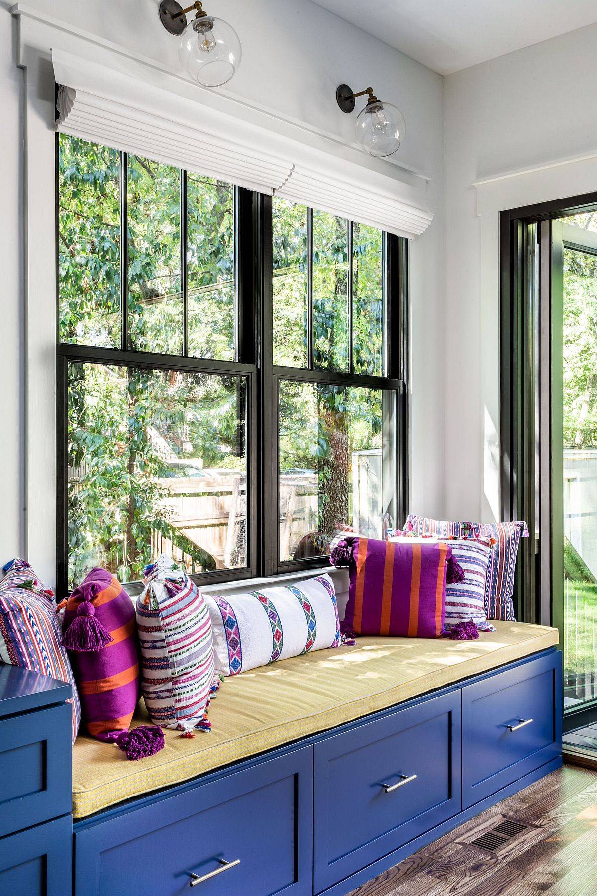 Tiny built-in bench with blue drawers and a comfortable sitting space that overlooks the garden