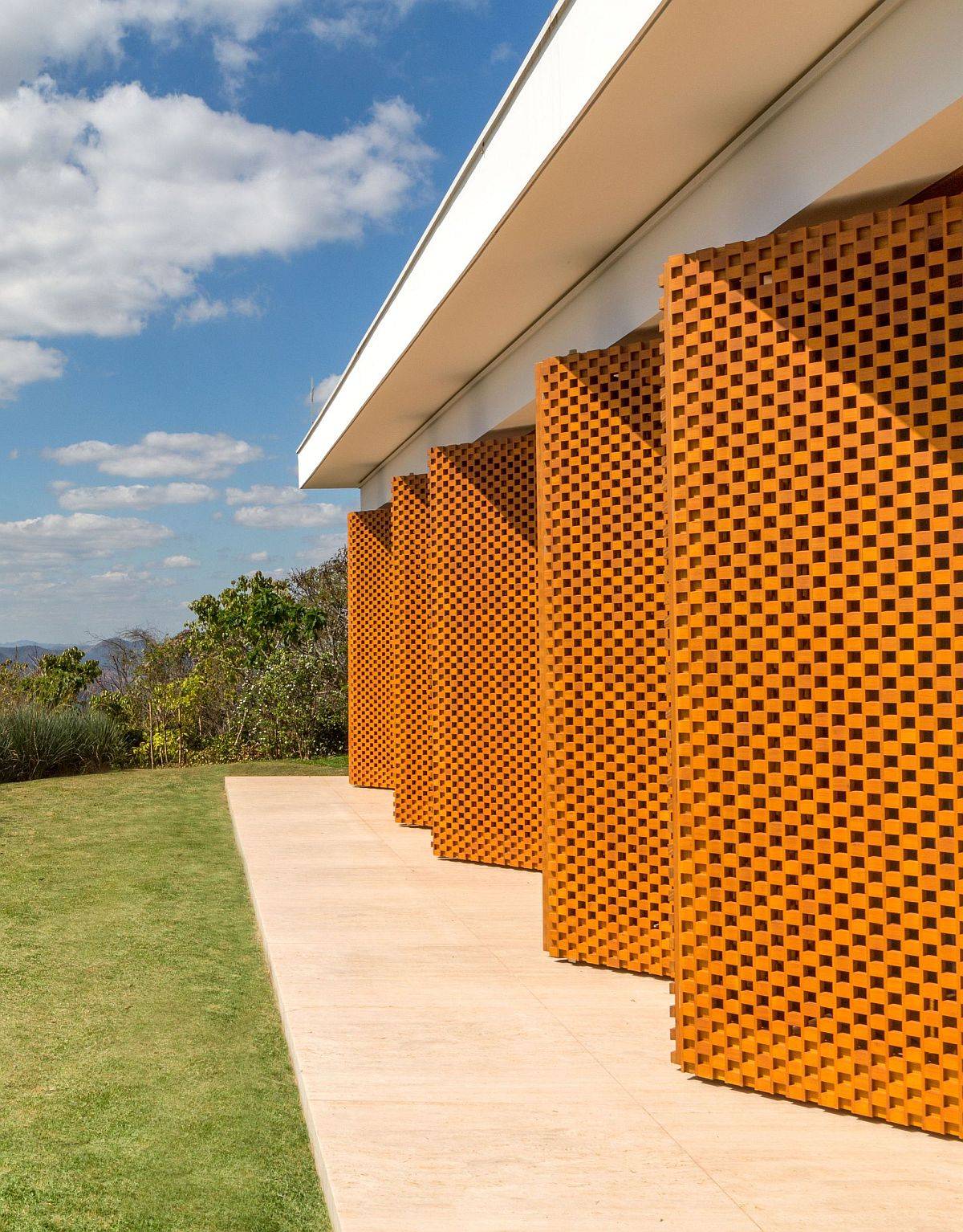 Custom pivoting wooden panels with perforated design give the home a unique identity