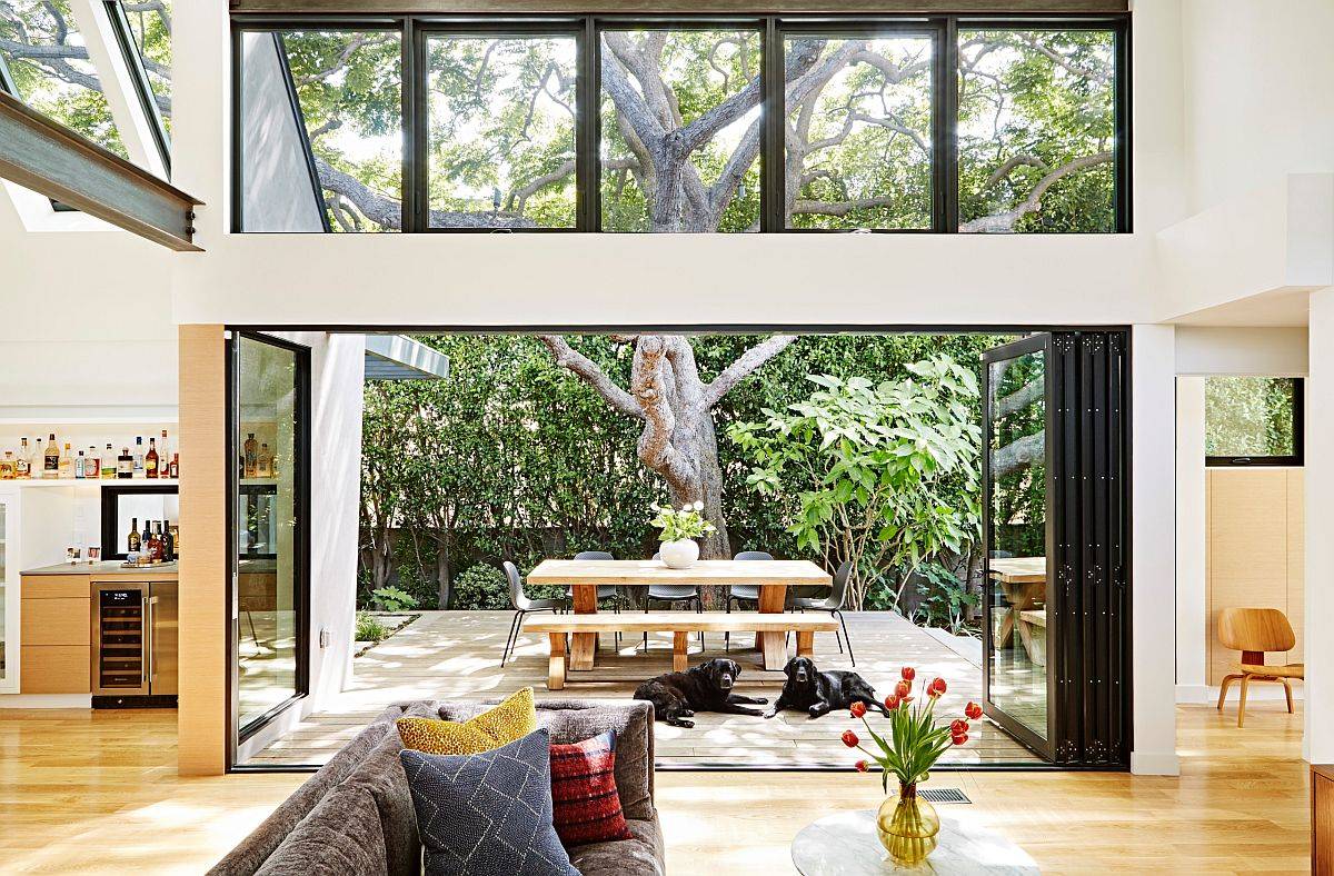 Lush green courtyard and outdoor dining area connected with the living room for an open, airy appeal