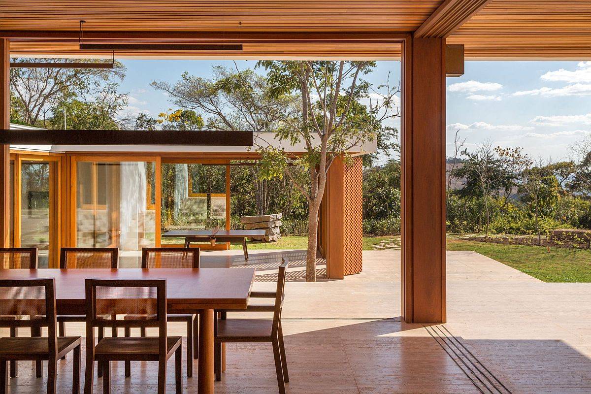 Sliding doors, folding wall sections and pivoting wood panels completely open the dining room to the view outside