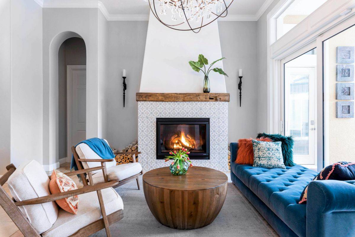 Beautiful fireplace, chaise lounge in blue and a couple of club chairs create this sophisticated modern living room