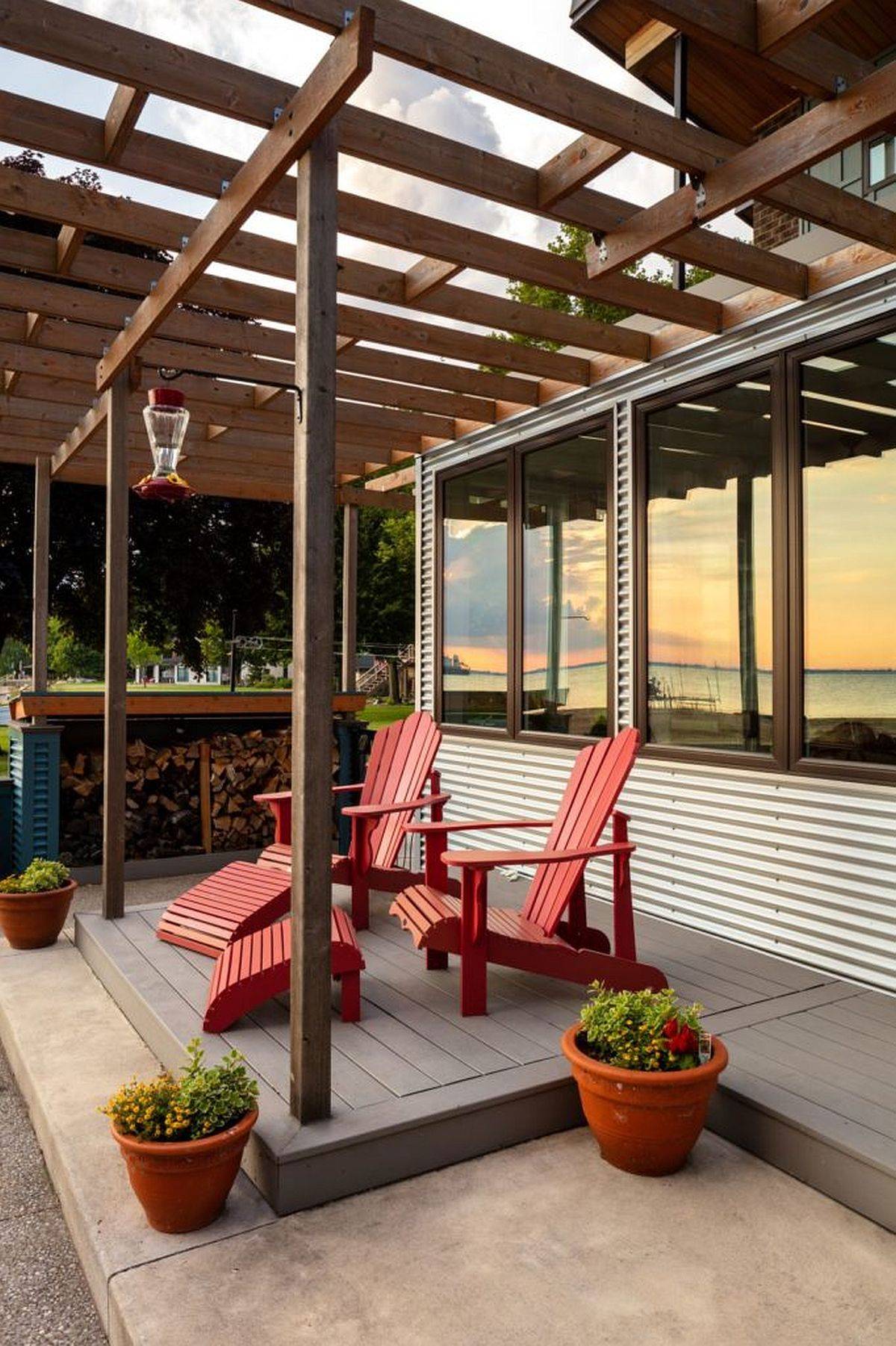 Colorful-chairs-in-red-add-a-touch-of-rustic-charm-to-the-deck-with-cedar-trellis-aove-and-water-views-13400