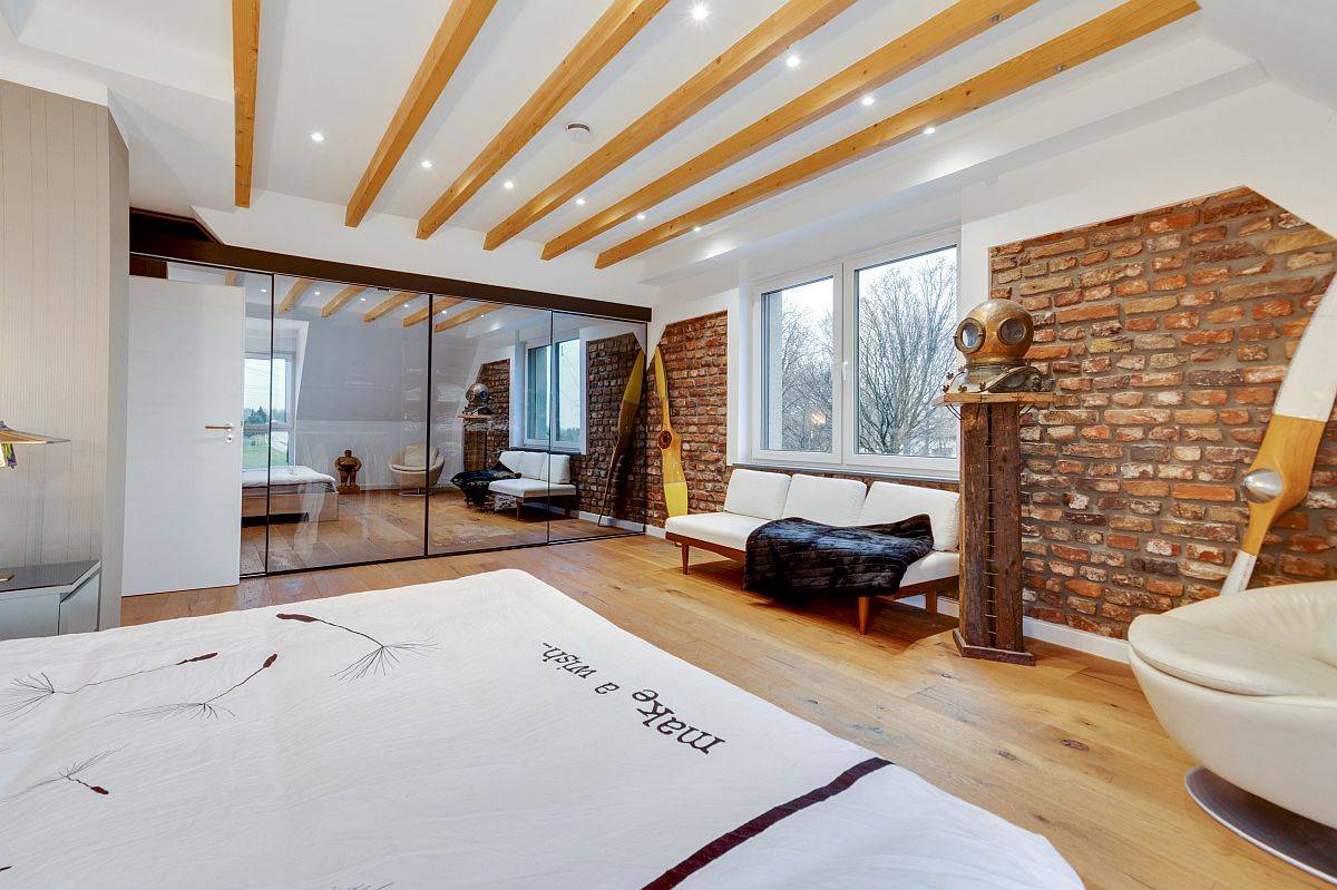 Exposed wooden ceiling beams, brick walls and a backdrop in white for the classy eclectic bedroom