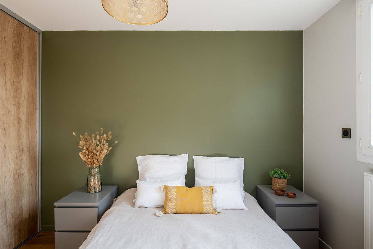 Green accent wall in the small apartment bedroom transforms the ambiance of the space