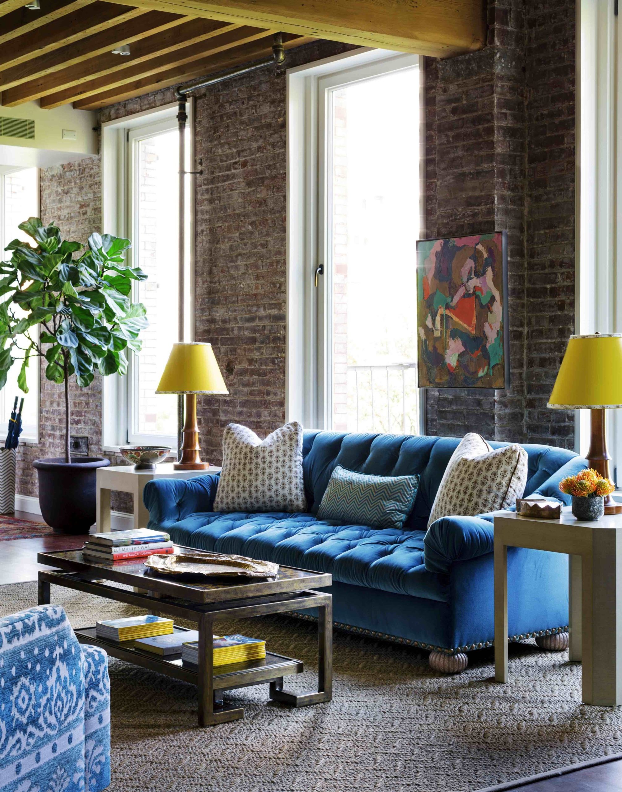 Exposed brick walls and blue sofa are a charming combo (from Jenny San Martin Design)