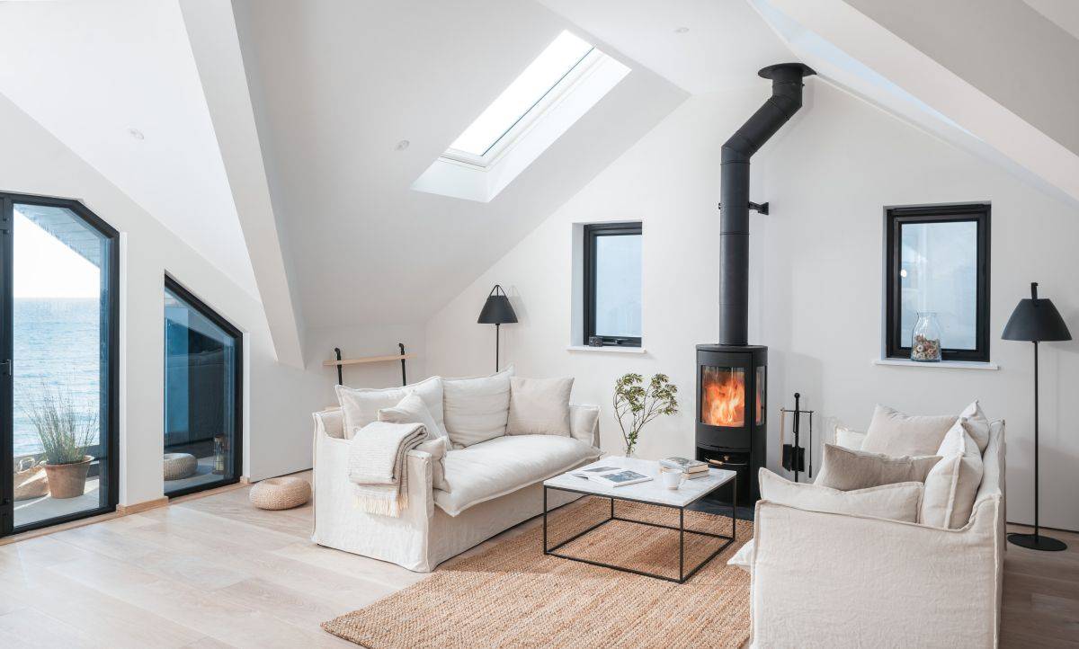 Skylights bring ample natural light into this beach style living space with fireplace