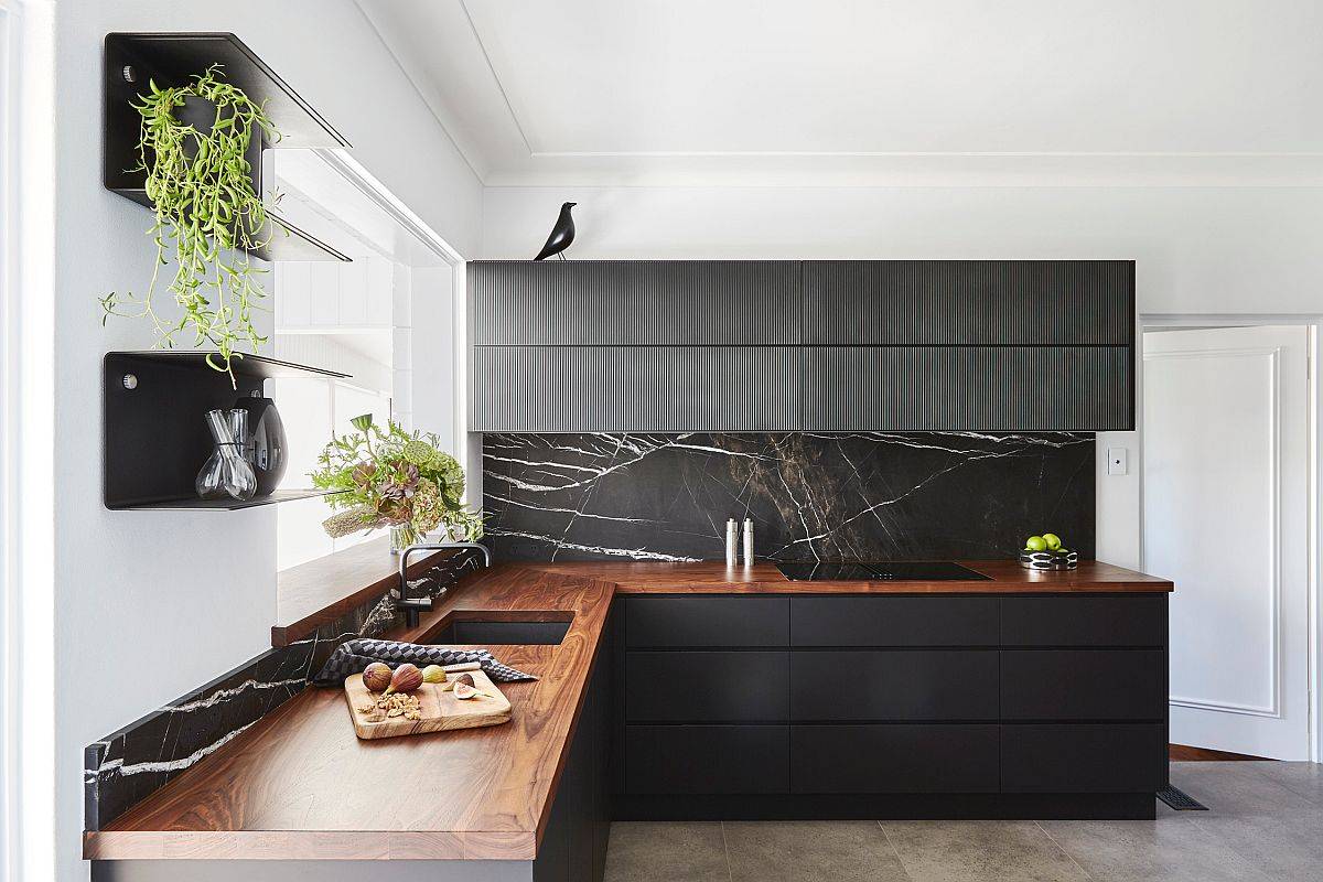 Stone black backsplash combined with wooden countertops in the polished contemporary kitchen