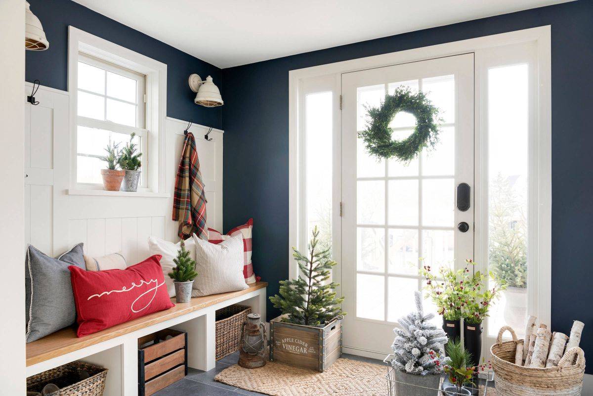 Dark blue and white entry with a lovely green wreath, indoor plants and plenty of festive cheer