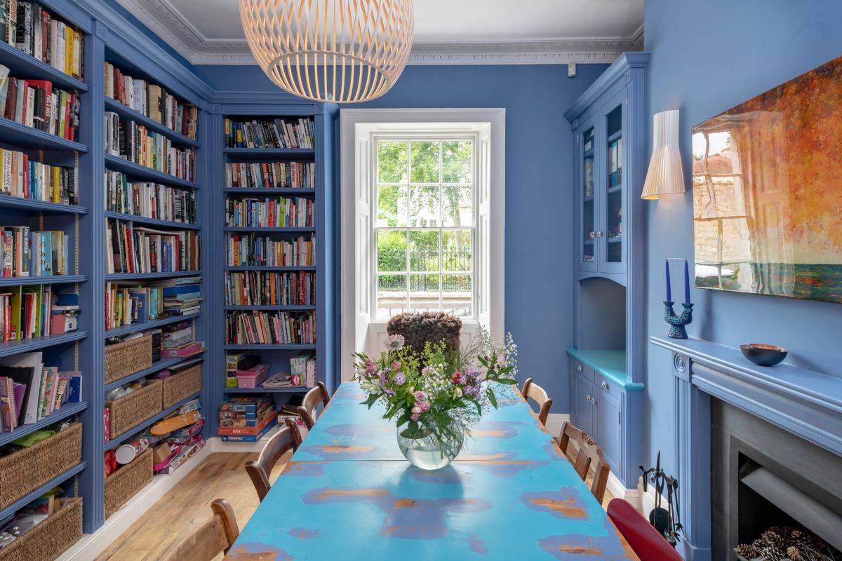 Dining room built for the bibliophile with blue walls and a white ceiling