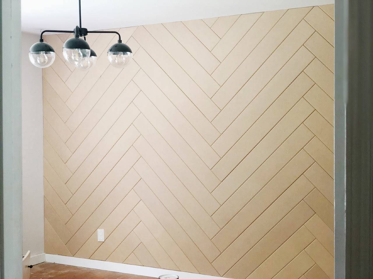 Chevron wood accent wall and a unique light fixture.