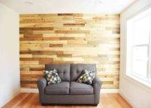 Shiplap wood accent wall fronted by a grey couch.