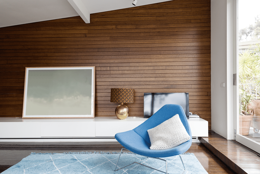 Tongue and groove paneling in a room with a blue modern chair.