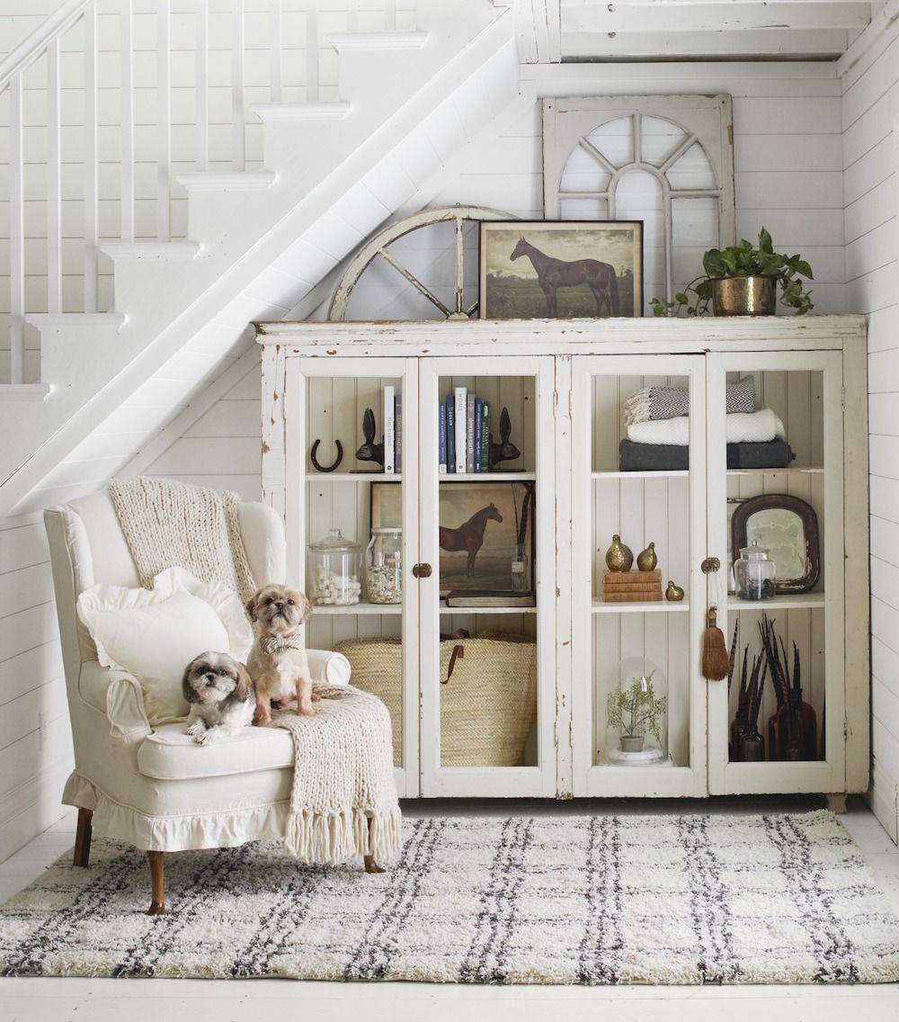 Stairway entryway with a storage cabinet and a chair.